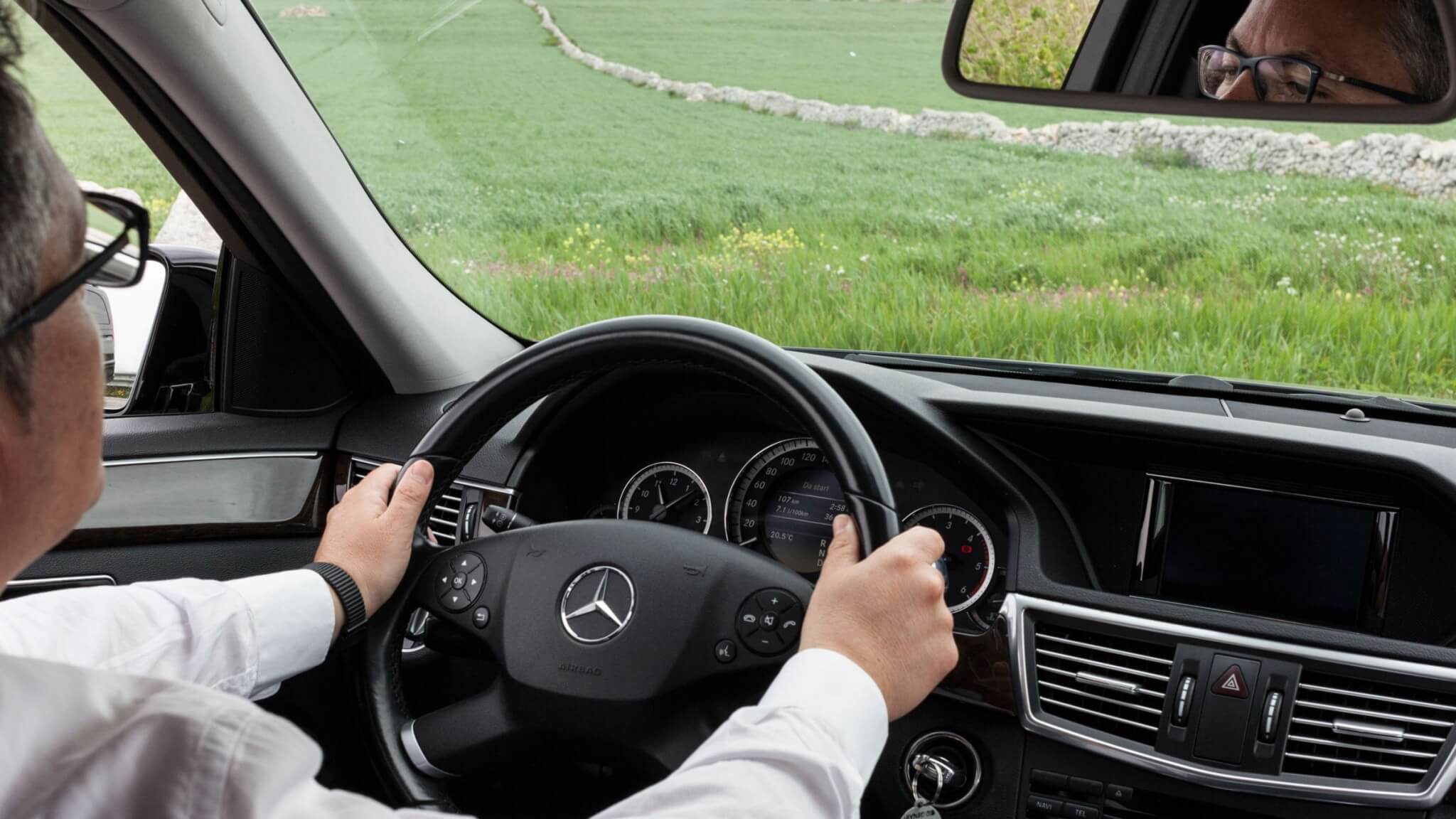 a driver in a luxury car driving through Sicily for an airport transfer