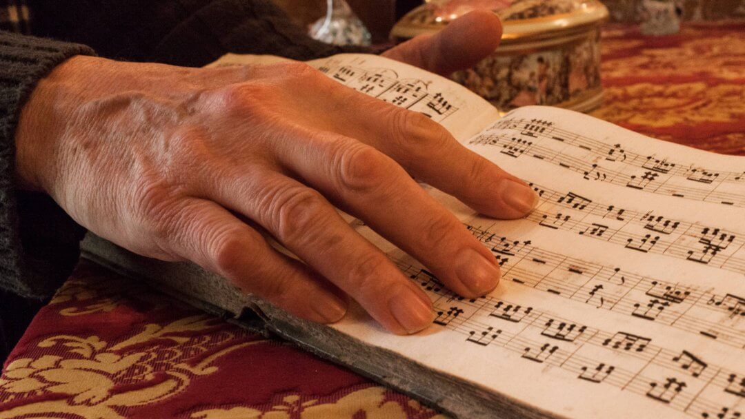the hand of a musician pointing at a musical paper, this is one of the true people of sicily